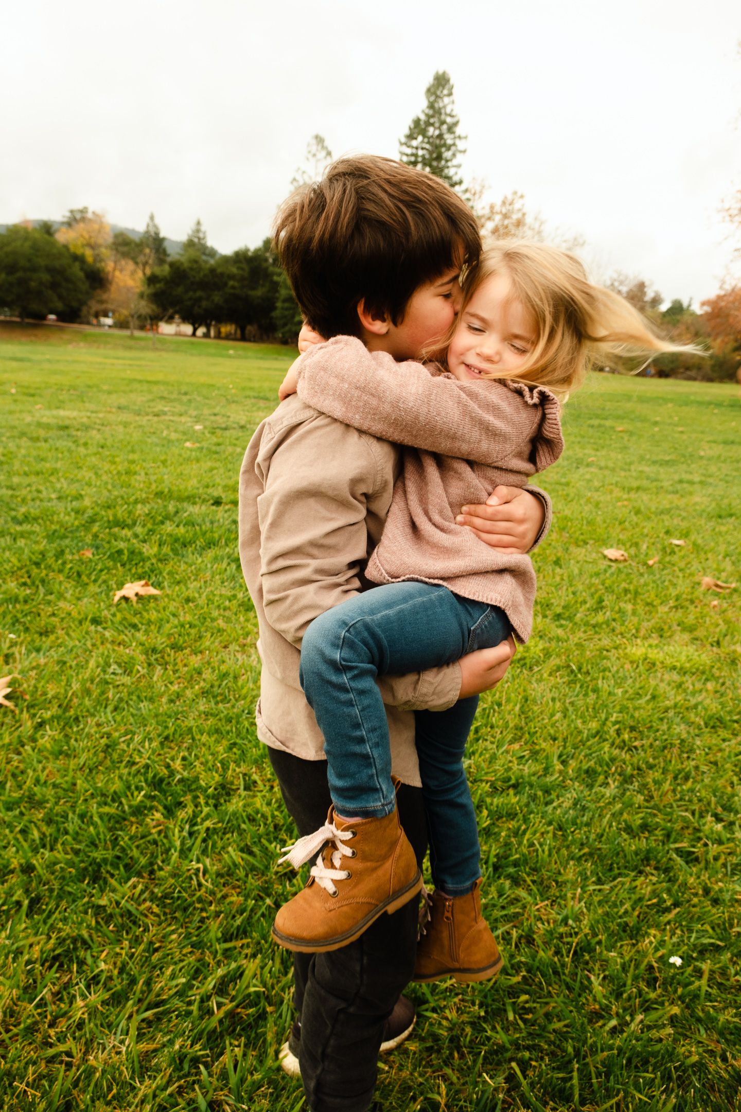 Sweet candid moments of affection captured in a series on a grassy field.