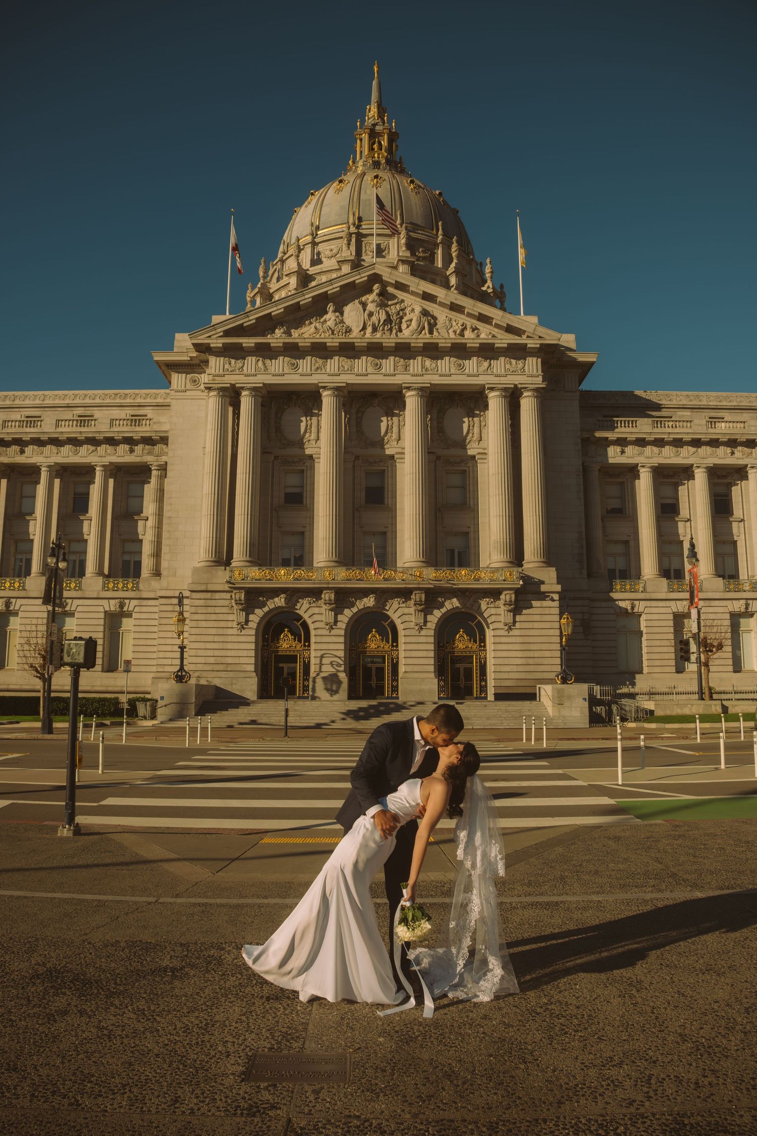 Wedding couple posing in front of San Francisco City Hall's grand architecture.