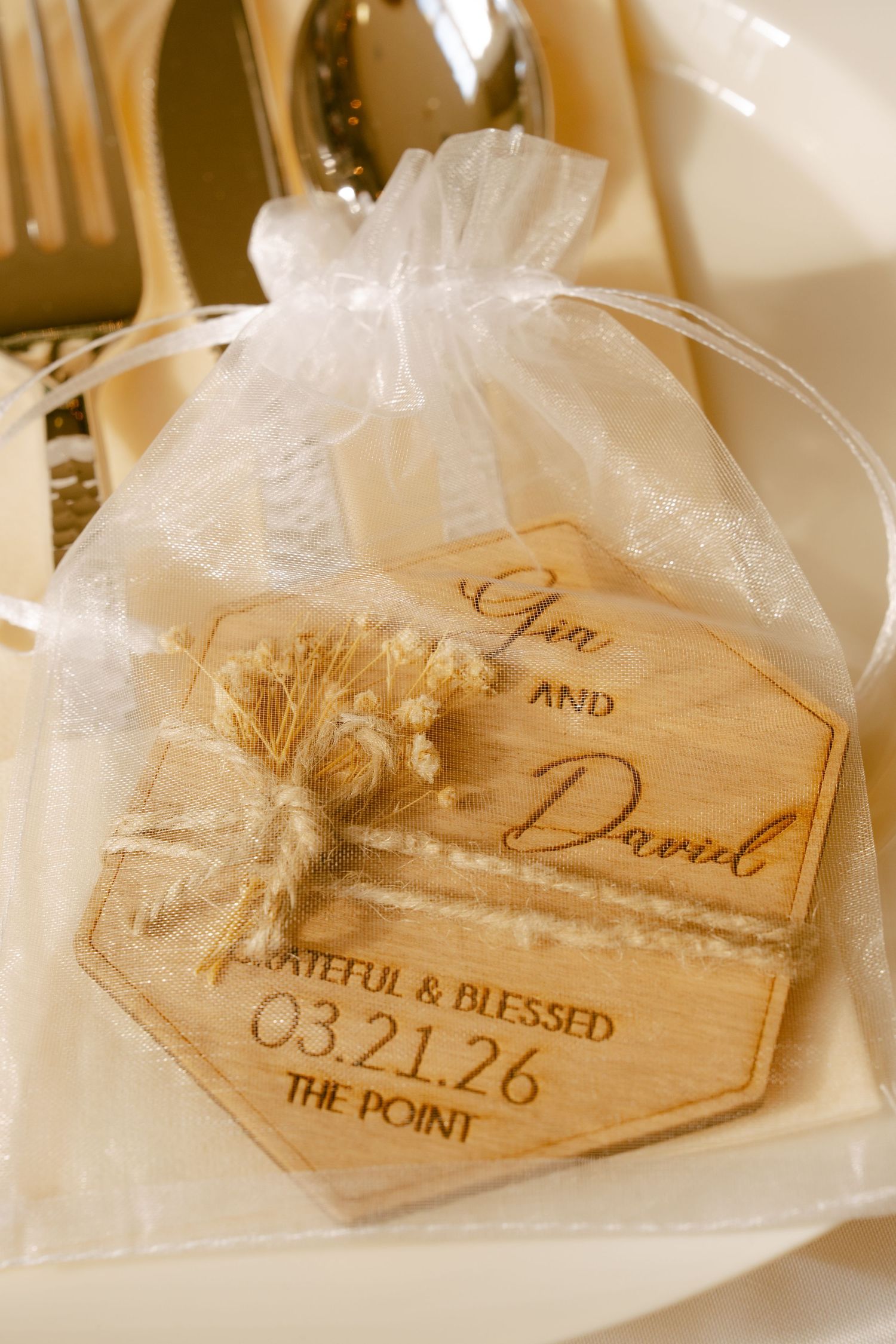 Engraved wooden hexagon wedding favor for Gia and David dated 03.21.26 in an organza bag.