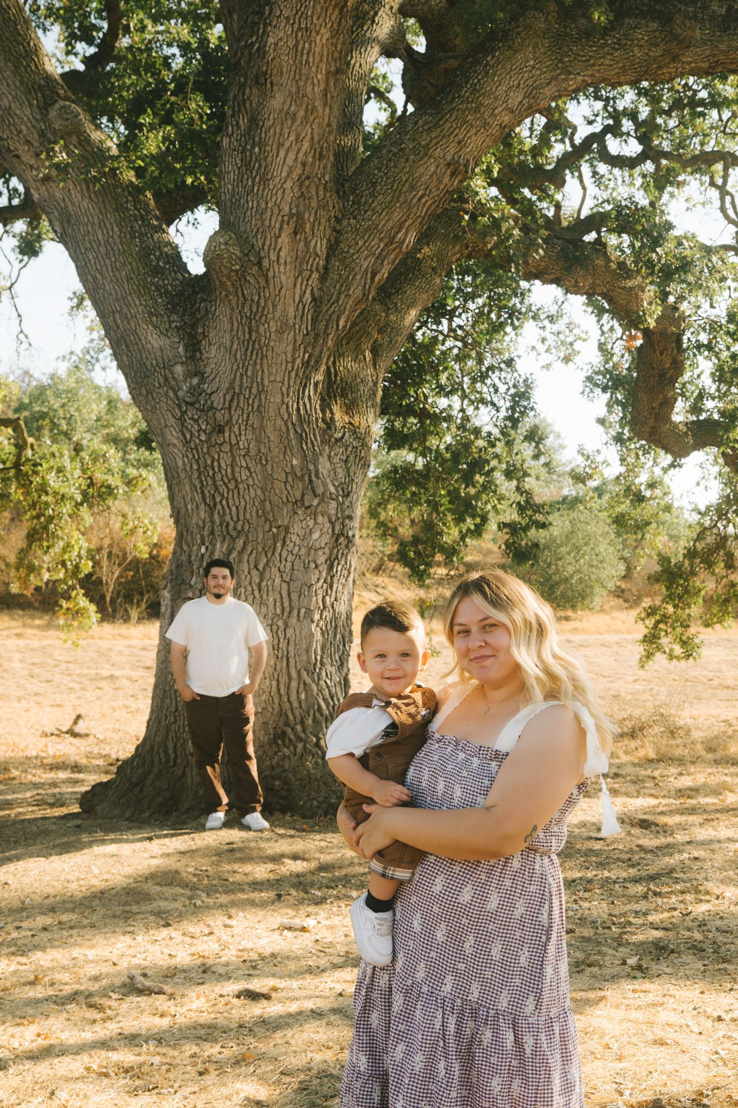 Playful family photo session beneath a majestic oak tree.