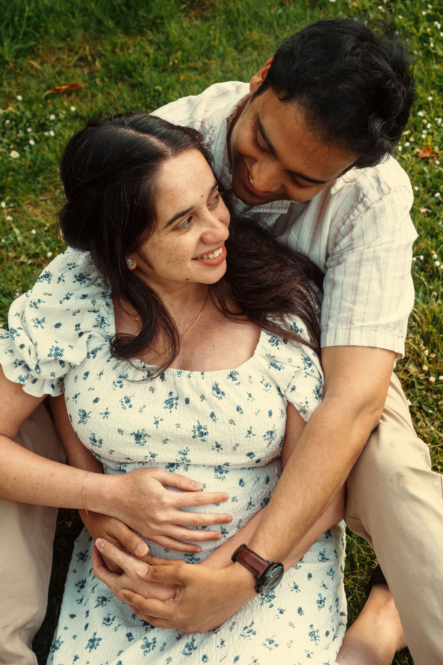 Couple sharing intimate moments while sitting in a flower-filled garden.