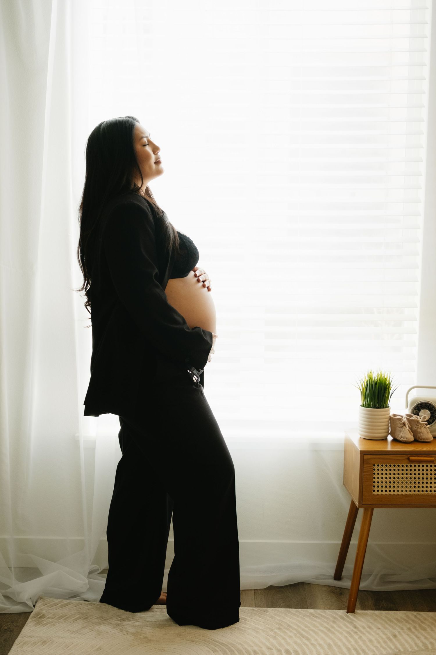 A series of silhouetted maternity photos showing a pregnant woman in black against a bright window backdrop.