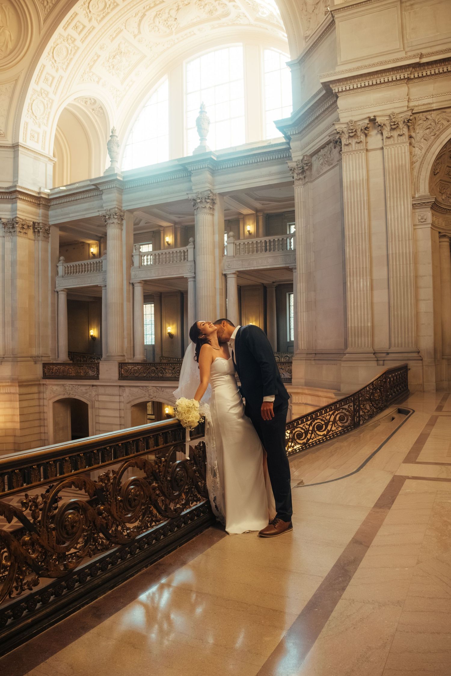 Elegant wedding photography sequence in a historic building with ornate railings and marble floors.