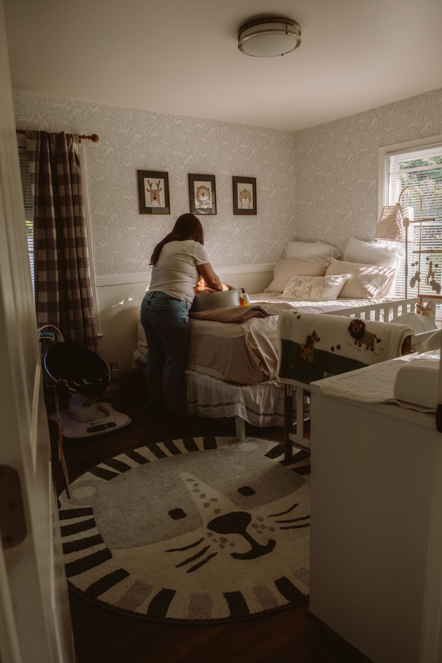 Interior bedroom with white bedding and a large circular black and white patterned rug on the floor.