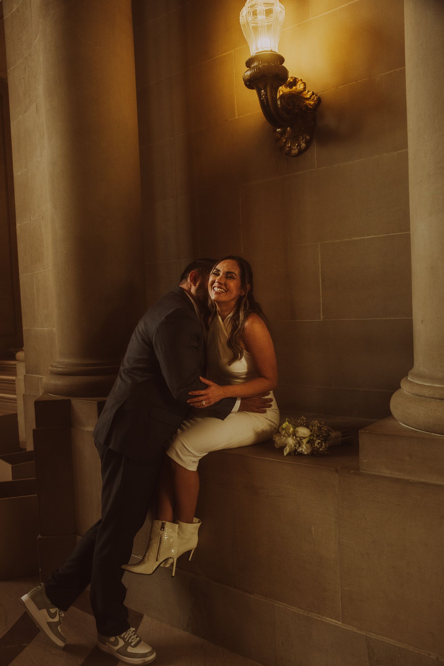 Romantic wedding portraits captured in warm lighting against classic stone architecture.