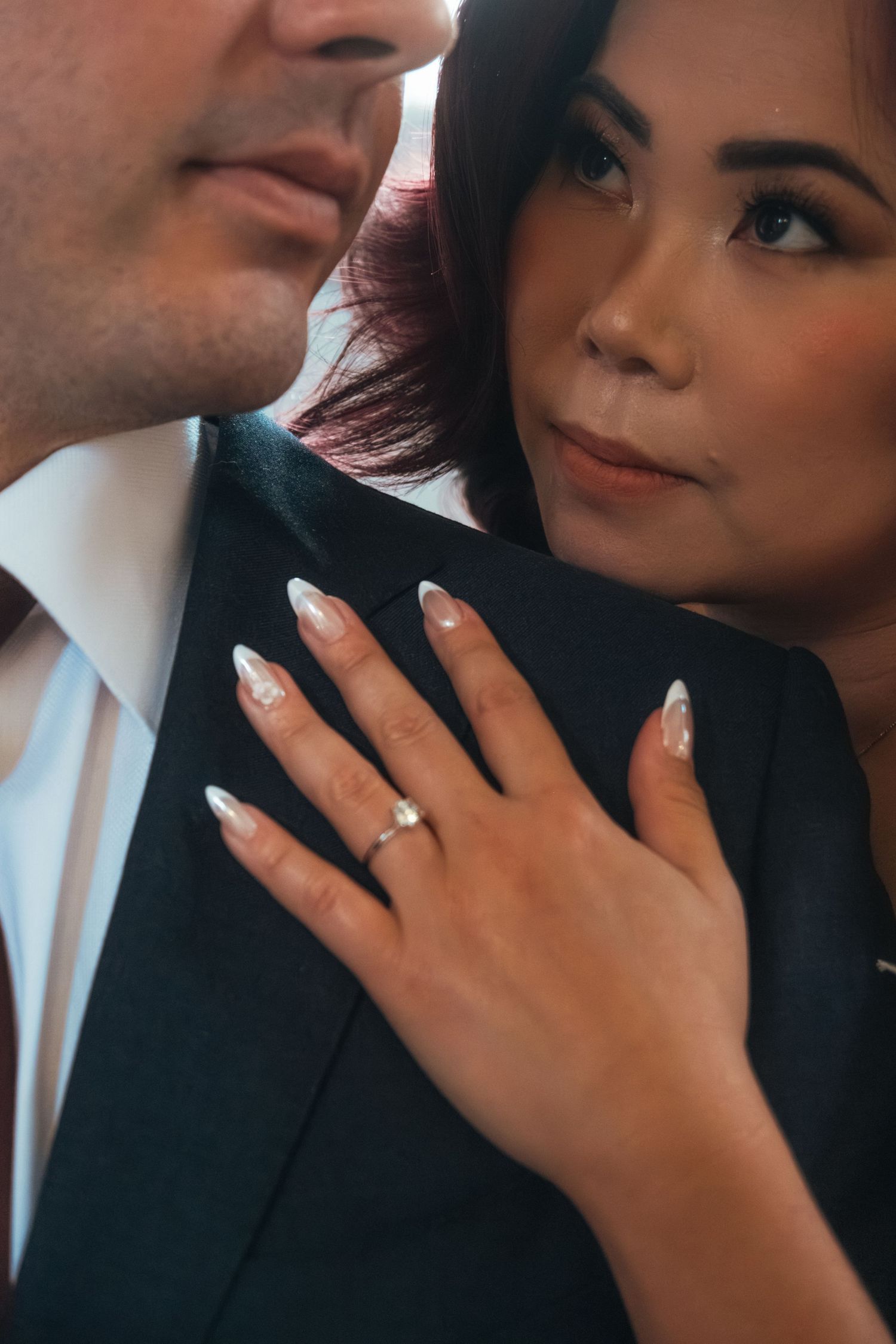 Intimate close-up portrait of couple sharing tender moment in formal attire.