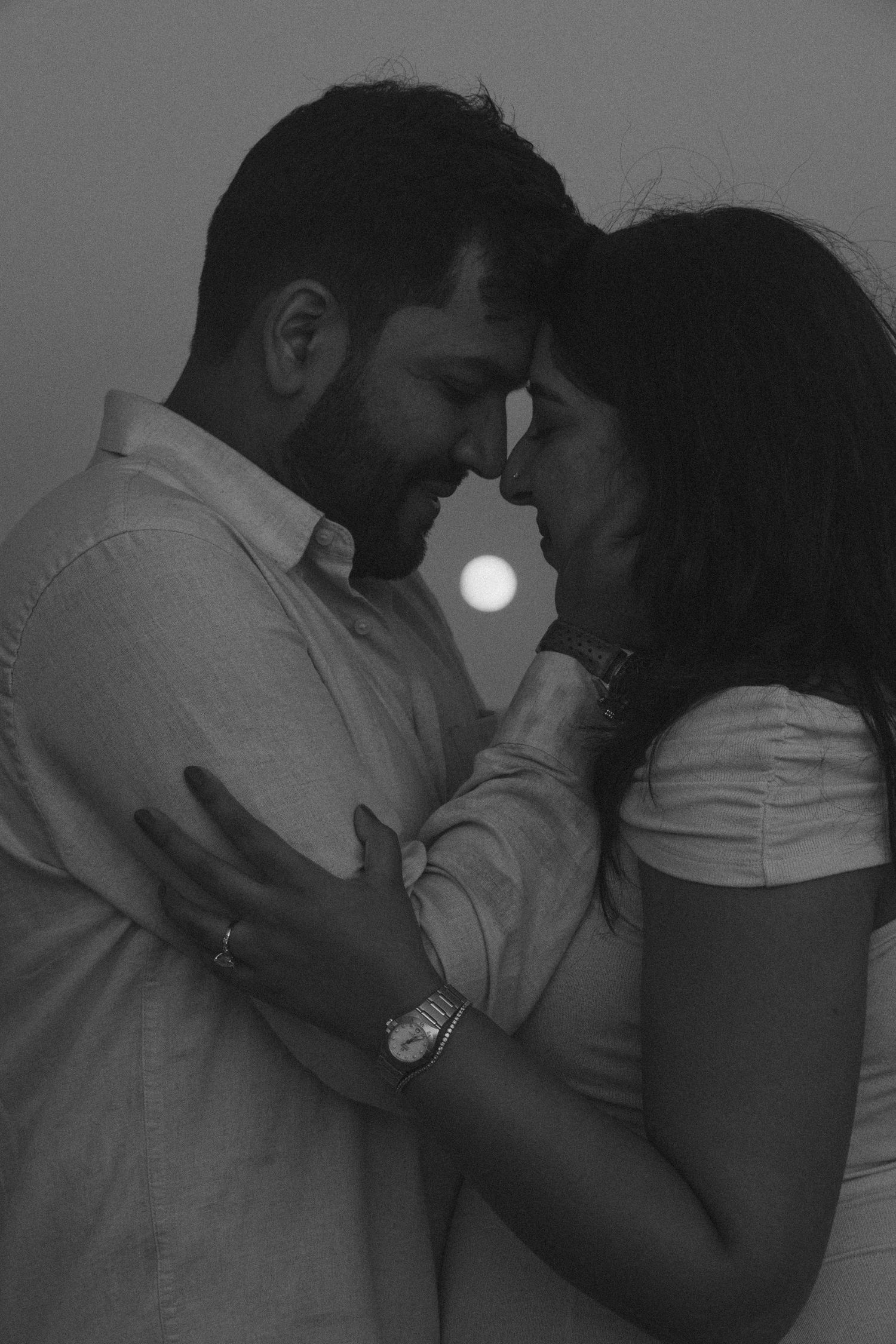 An intimate black and white portrait of a couple during sunset.