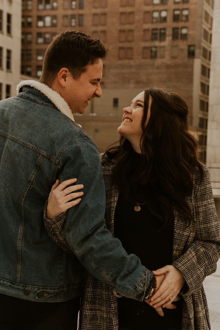 Intimate couple portraits against urban brick building backdrop in warm tones.