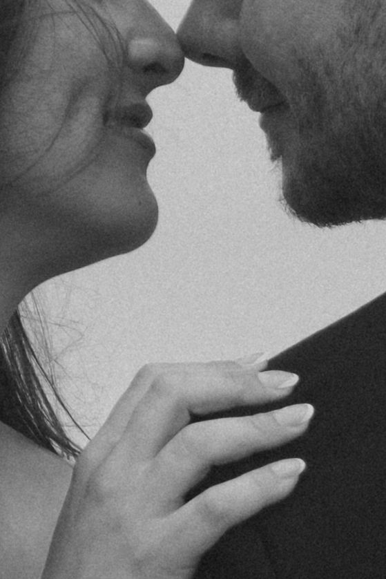 An intimate black and white close-up of a couple about to kiss.
