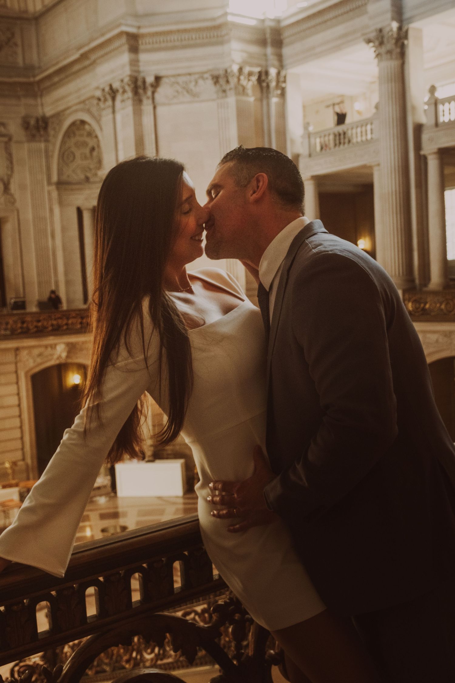 Warm-toned romantic moments inside City Hall's classical architectural interior.
