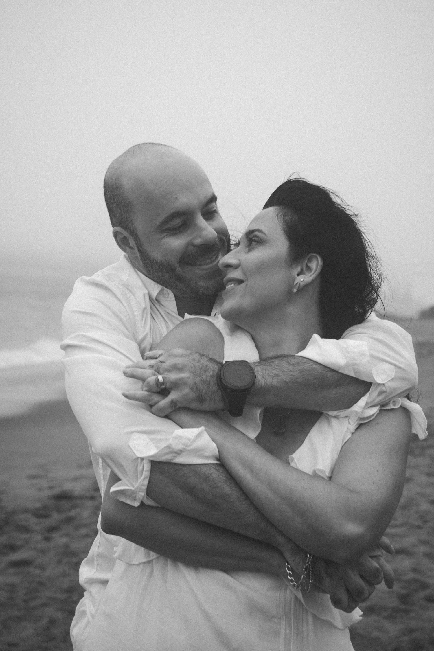 Romantic black and white photo sequence of a couple embracing and kissing on a beach.