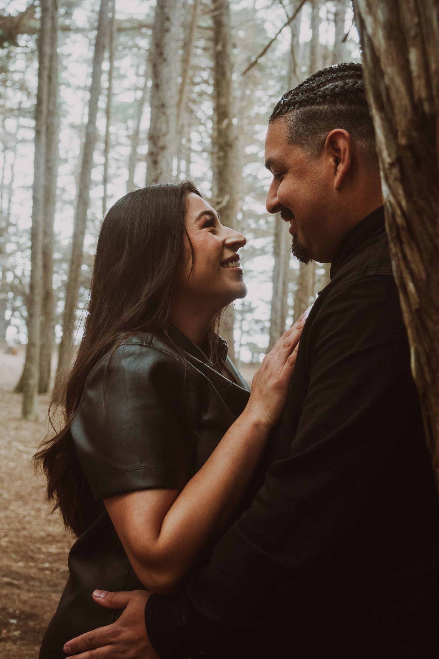 Couple sharing emotional moment in misty forest setting.