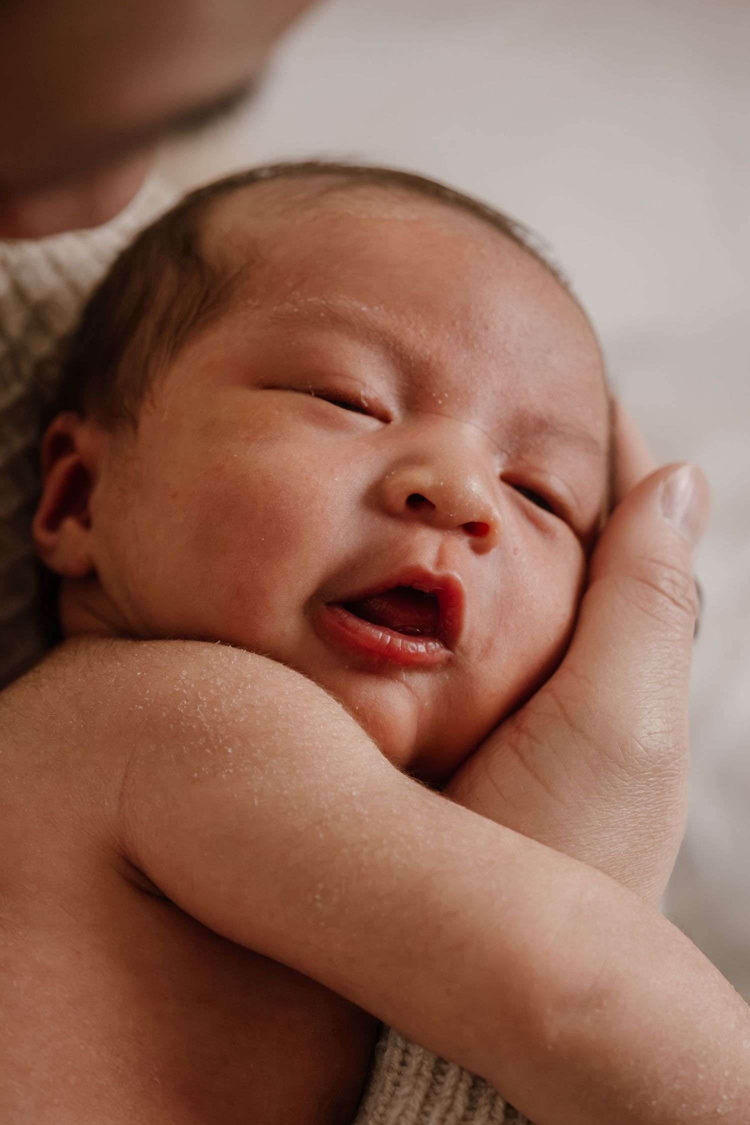 Close-up series of a sleeping infant's face in soft lighting showing peaceful expressions.