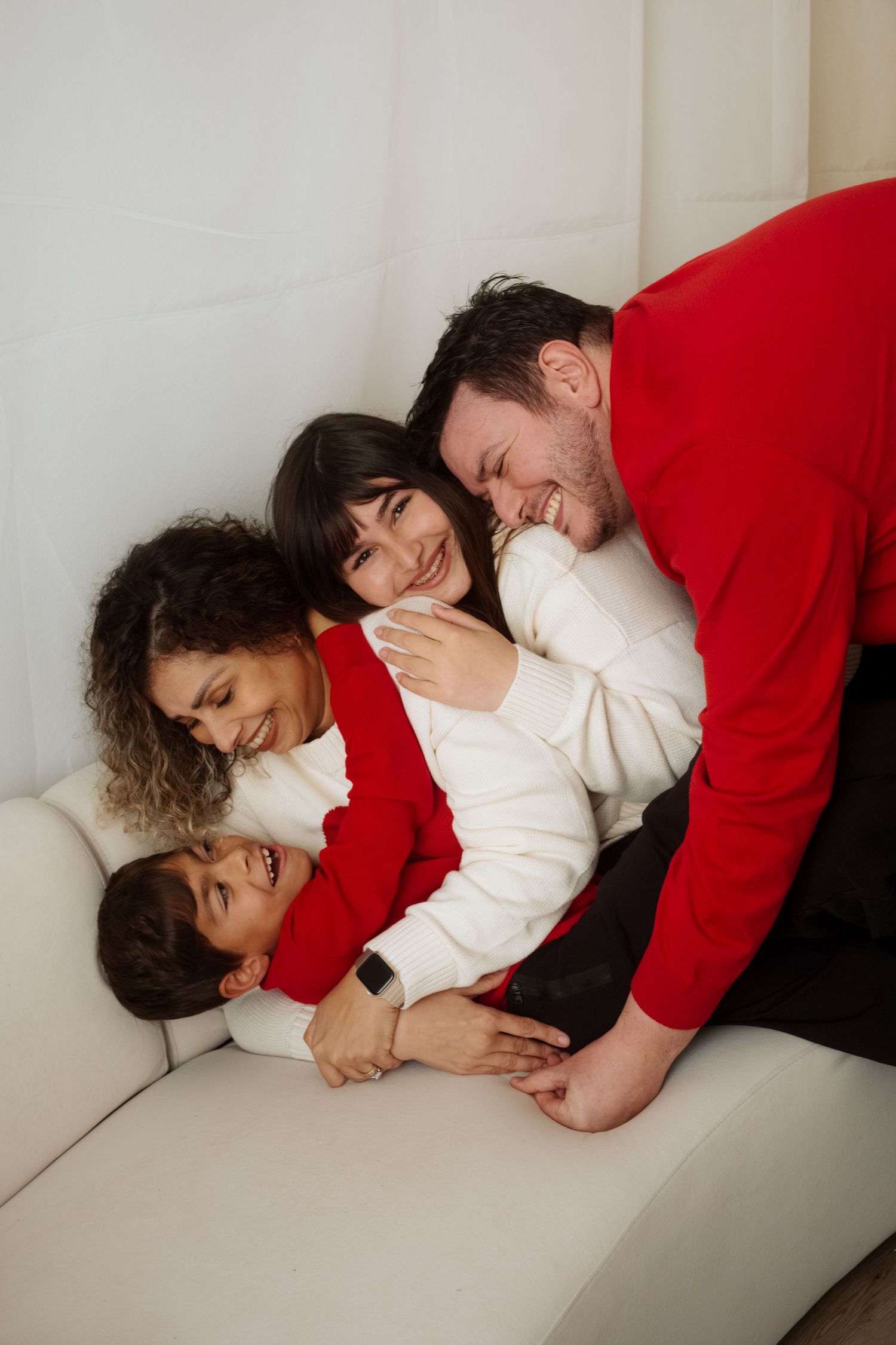 Intimate couple portraits on white couch with holiday decorations.
