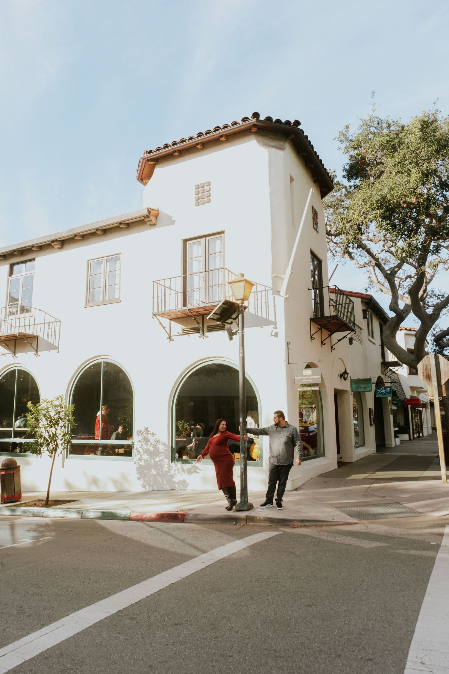 Spanish-style architecture with white walls and arched doorways creates a charming street scene.