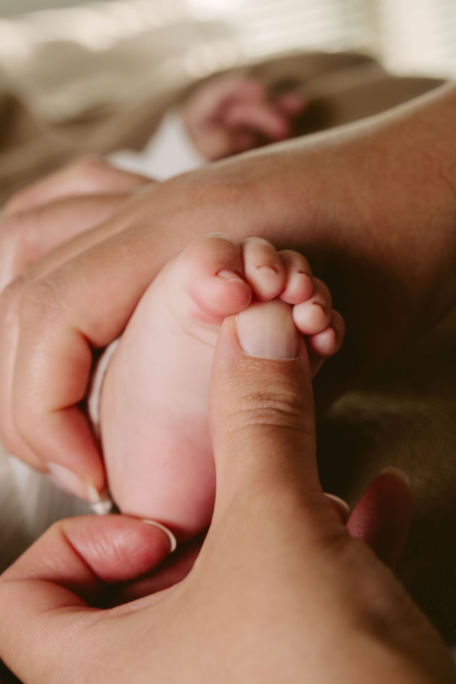 Gentle close-up shots of tiny baby hands being held.