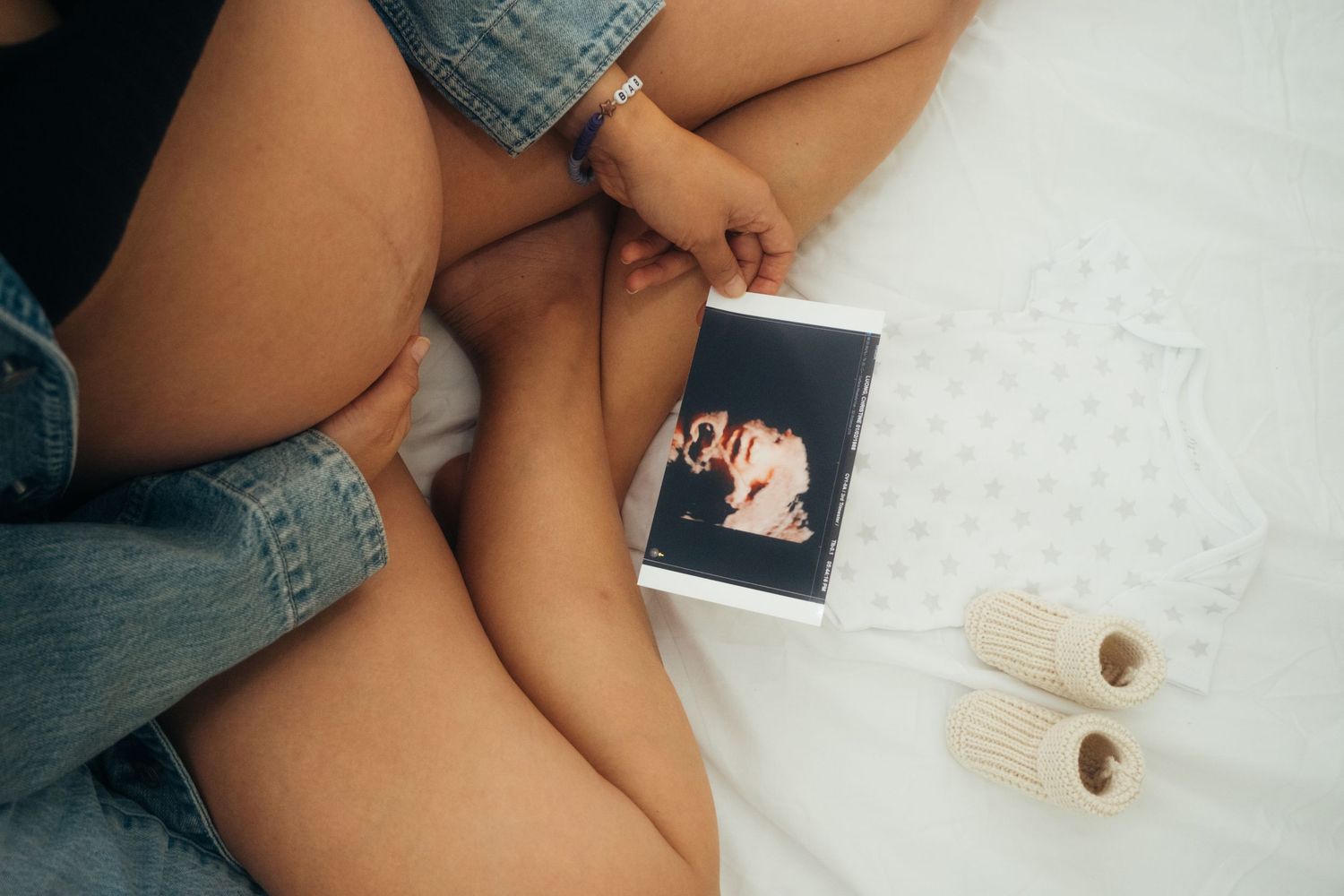 Casual maternity photos showing a pregnant belly against a white background.