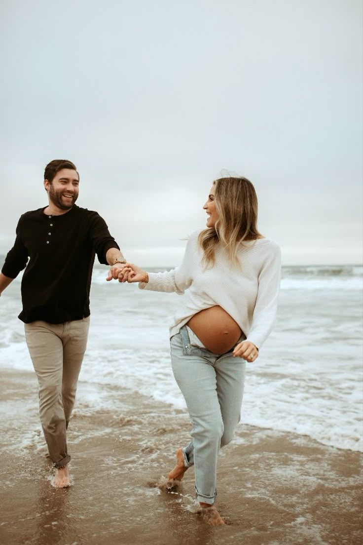 Playful couple splashing and laughing in ocean waves at the beach.