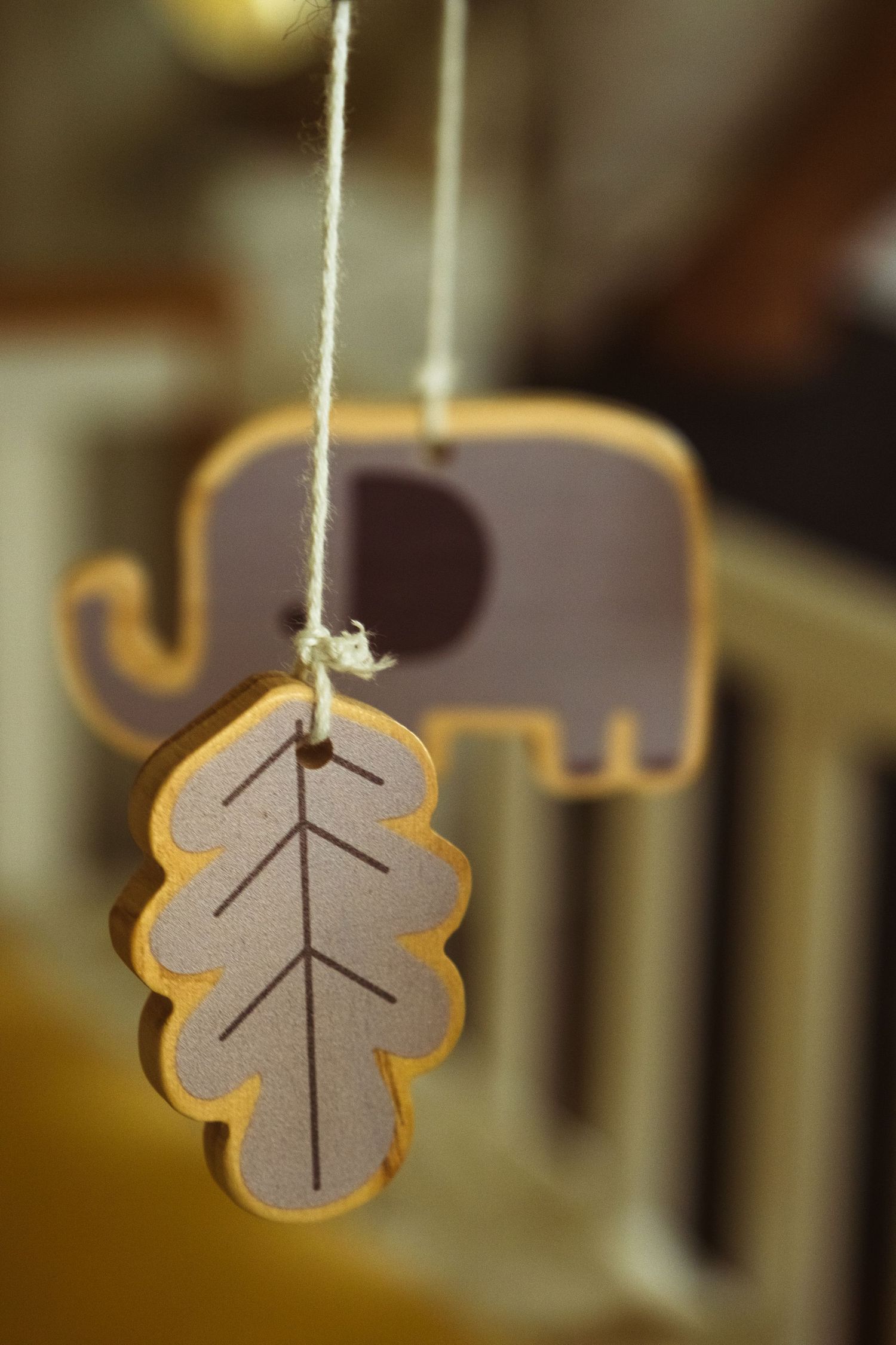 Decorative leaf-shaped ornaments hanging from strings in warm lighting.
