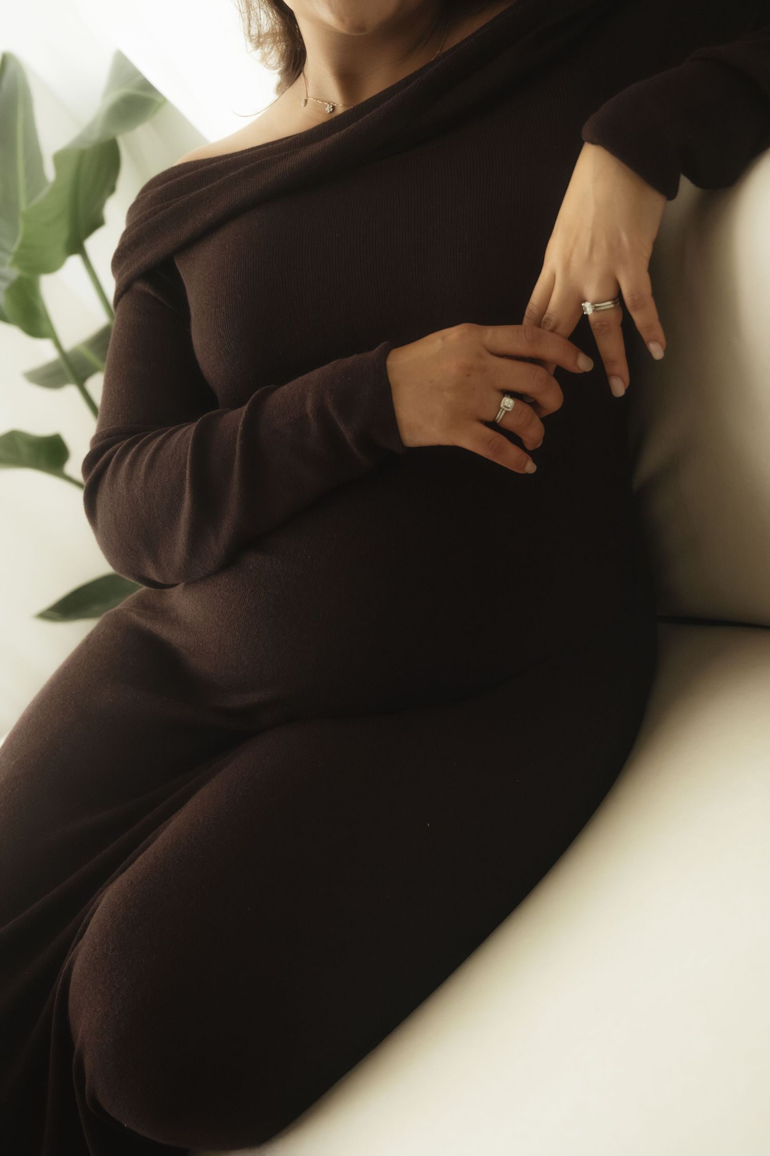 Close-up shots of a pregnant woman in a brown dress during an intimate photoshoot.