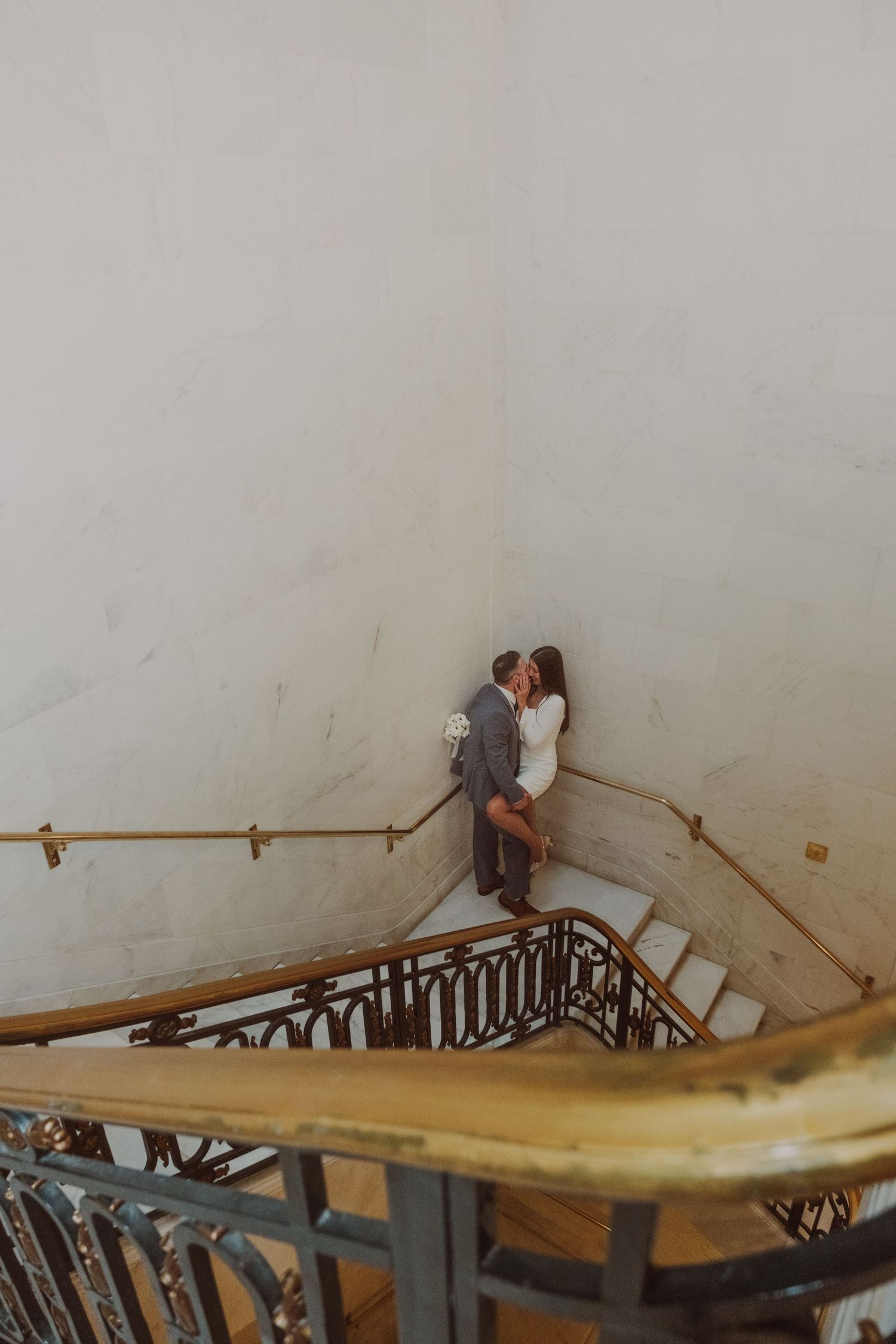 Intimate moment captured on historic wooden staircase with vintage railing.