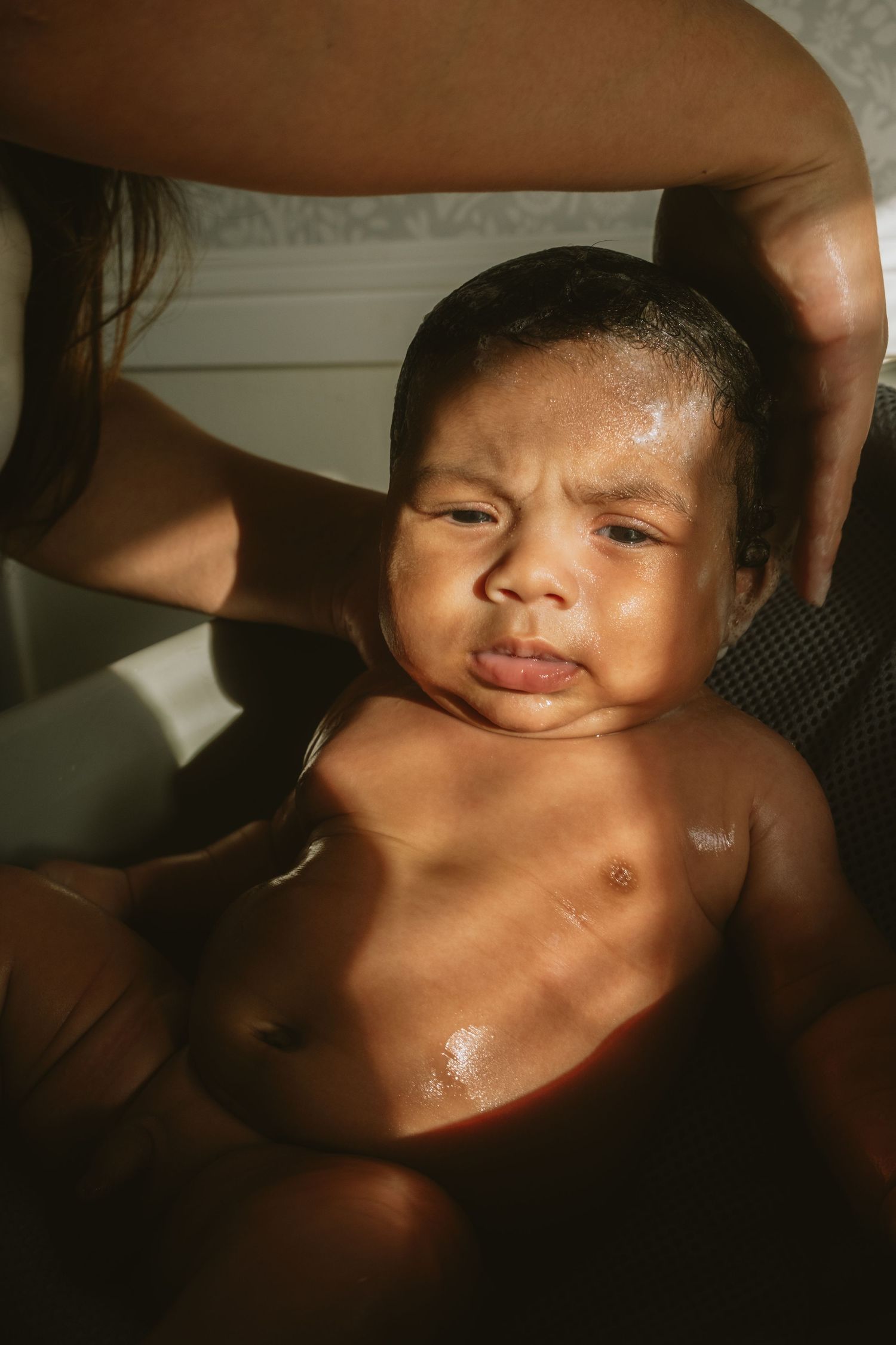 Artistic portrait of a baby with dramatic lighting and shadows.