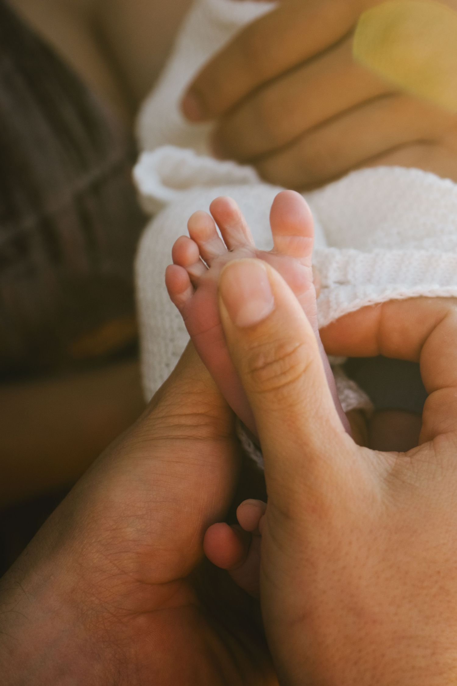 Close-up sequence showing gentle touch between adult and baby fingers.