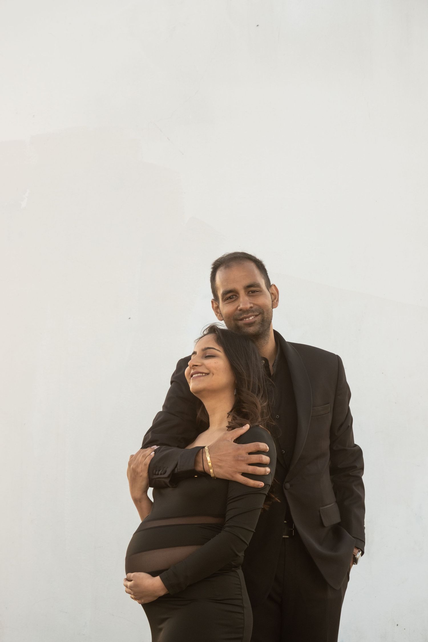 A couple embraces lovingly in a series of candid black and white portraits.
