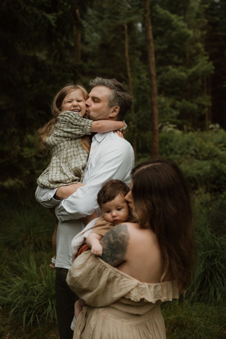 Sweet family moment captured in a wooded setting with natural lighting.