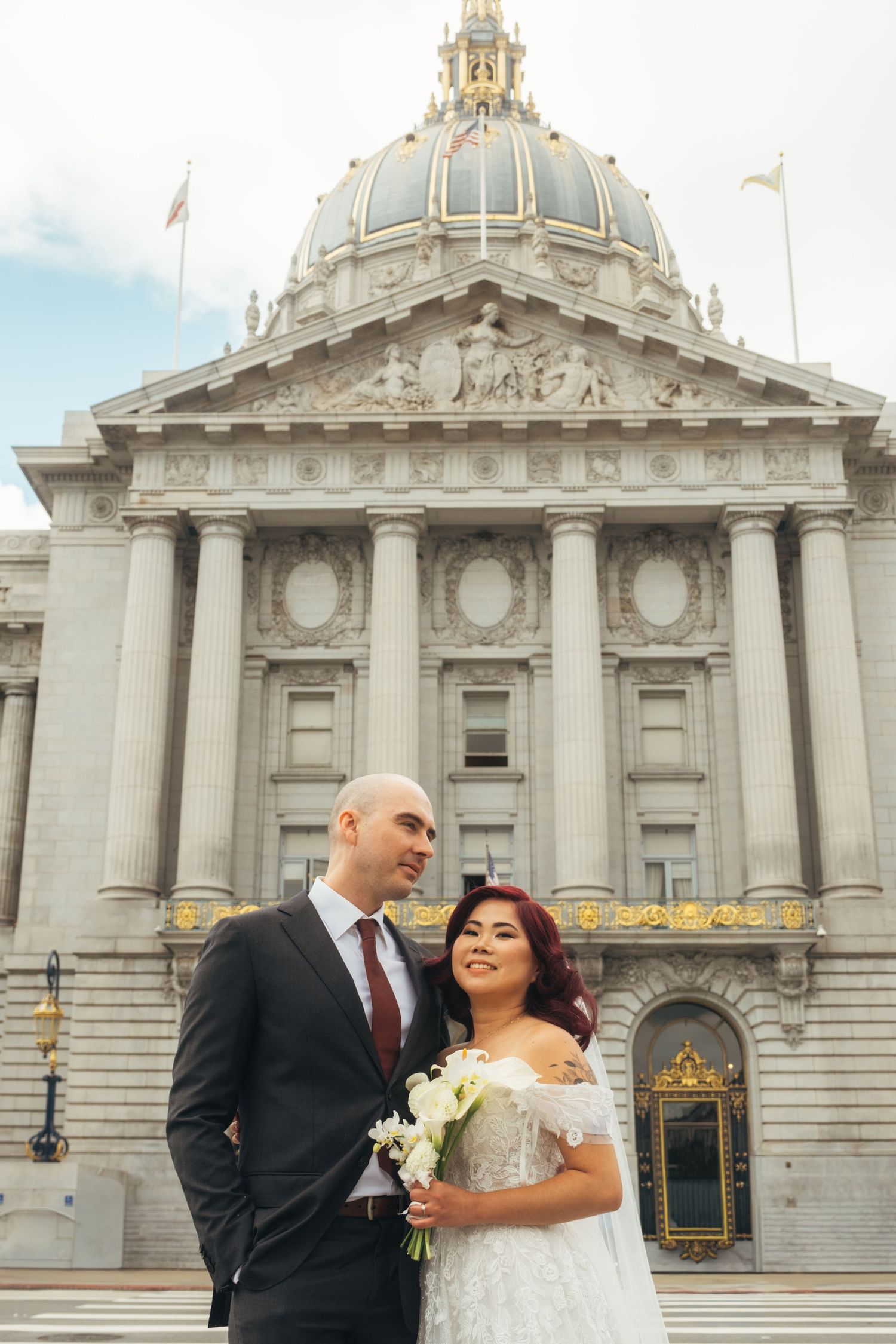 San Francisco City Hall's iconic Beaux-Arts architecture provides backdrop for wedding portrait.