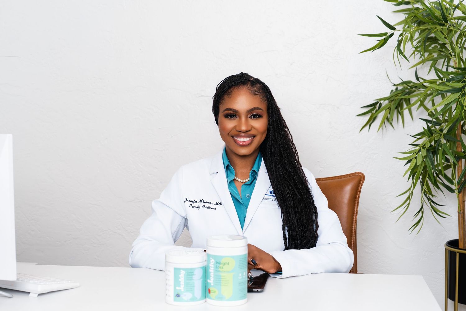 Professional physician headshot in South Florida with clean modern background and white coat branding photography.