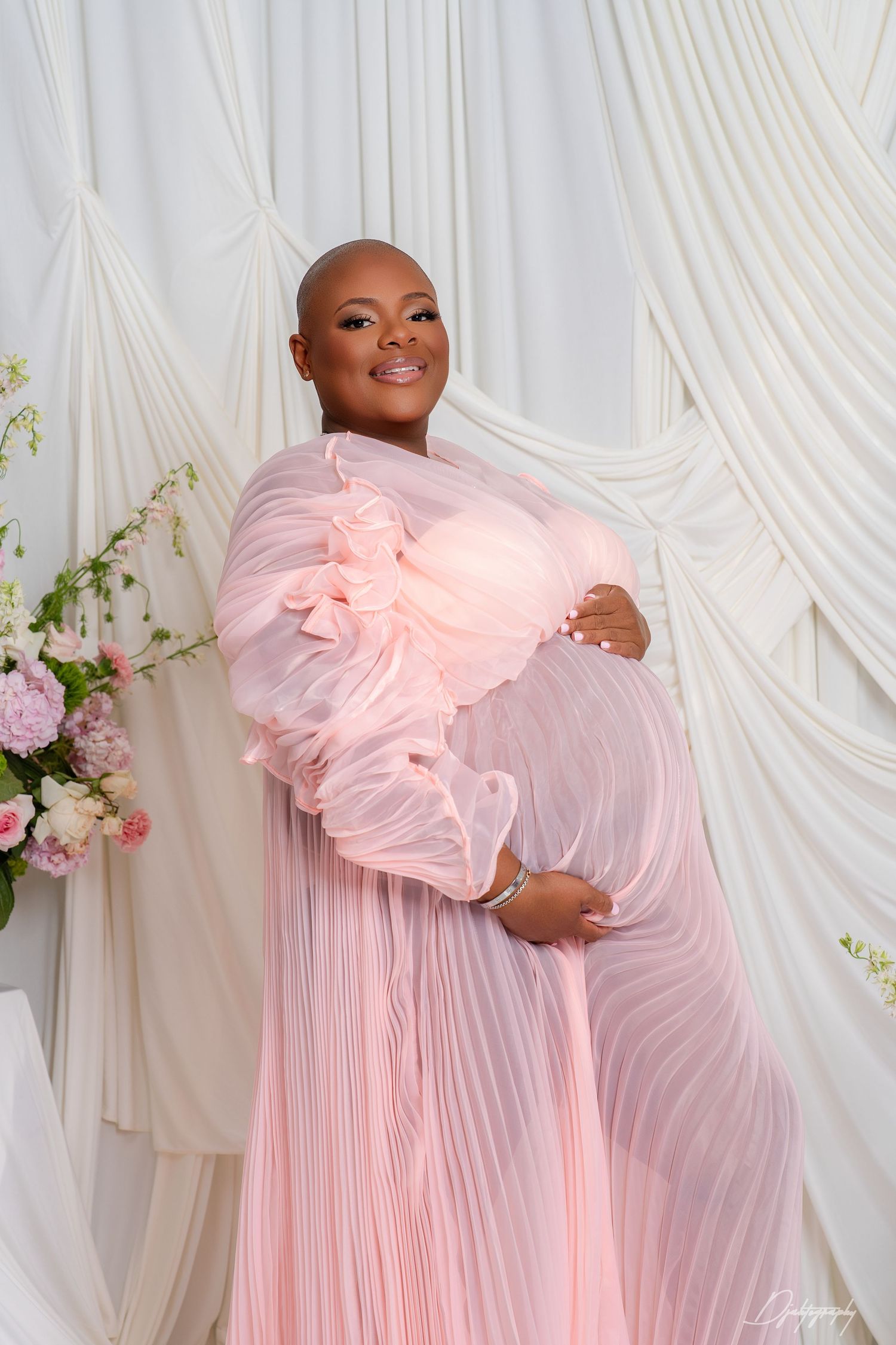 Maternity photoshoot in South Florida with soft pink dress and luxury studio lighting.