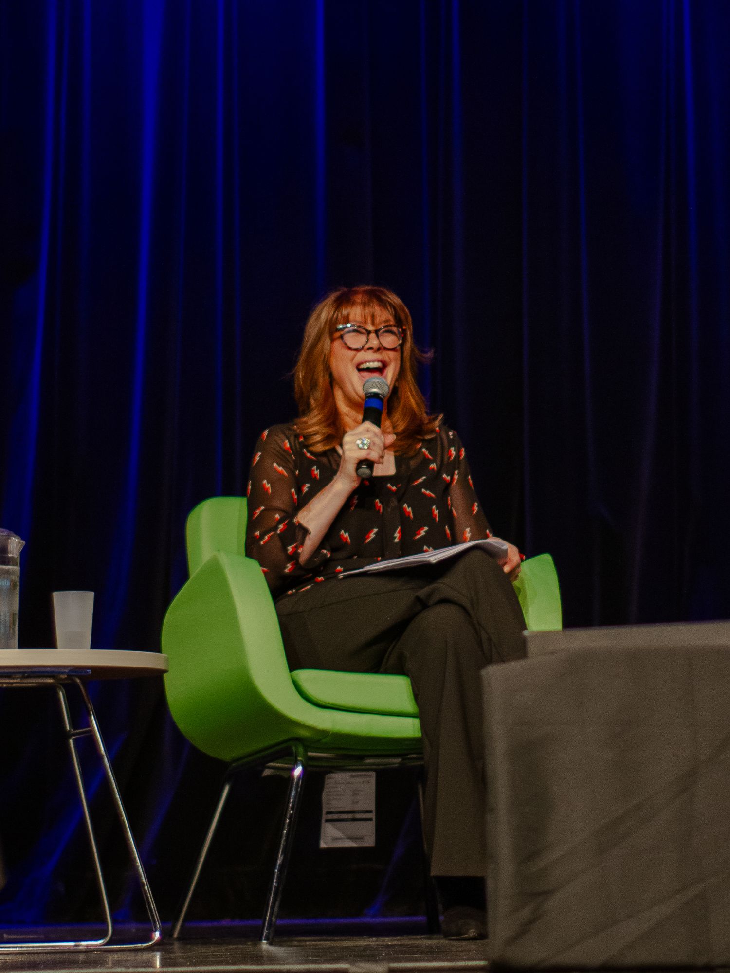 Conférencière Chantal Lacroix sur scène qui souris, à Québec. Photographie événementielle par BOLEA Photographe.