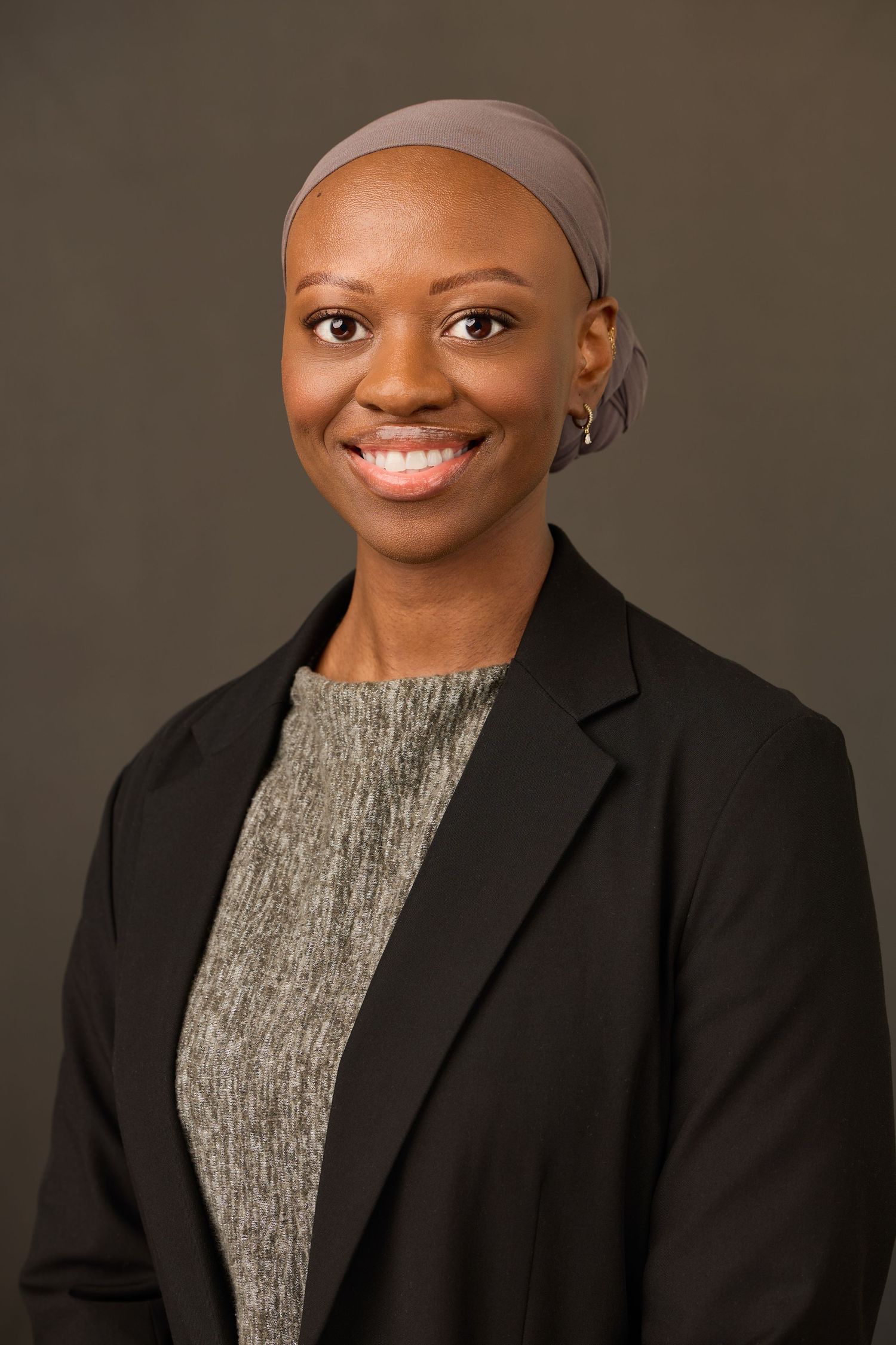 Professional headshot series showing someone wearing a black blazer and gray top against a dark background.