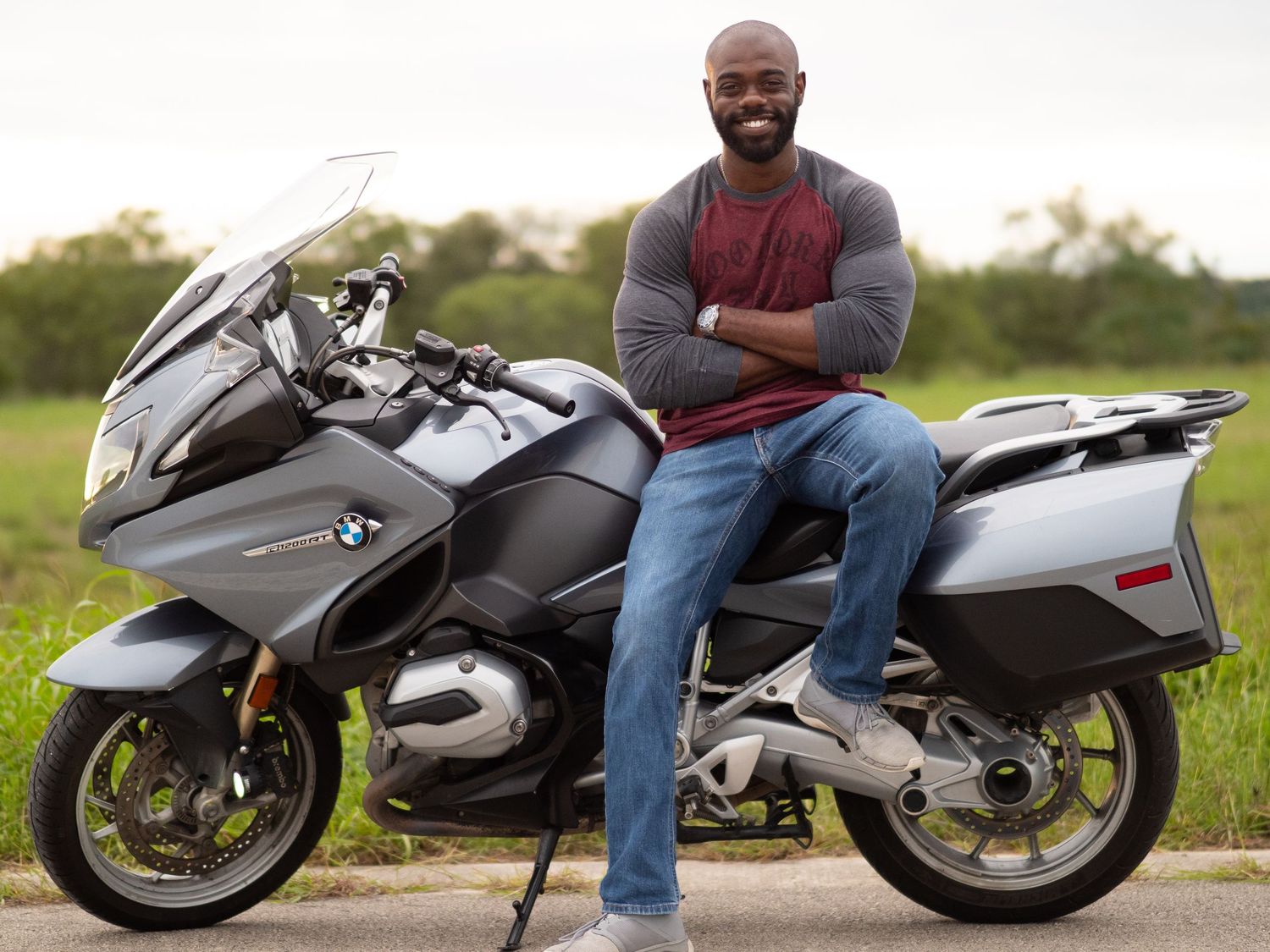 A sleek black and silver custom motorcycle with extended swingarm and sport bike styling sits parked on a rural road.