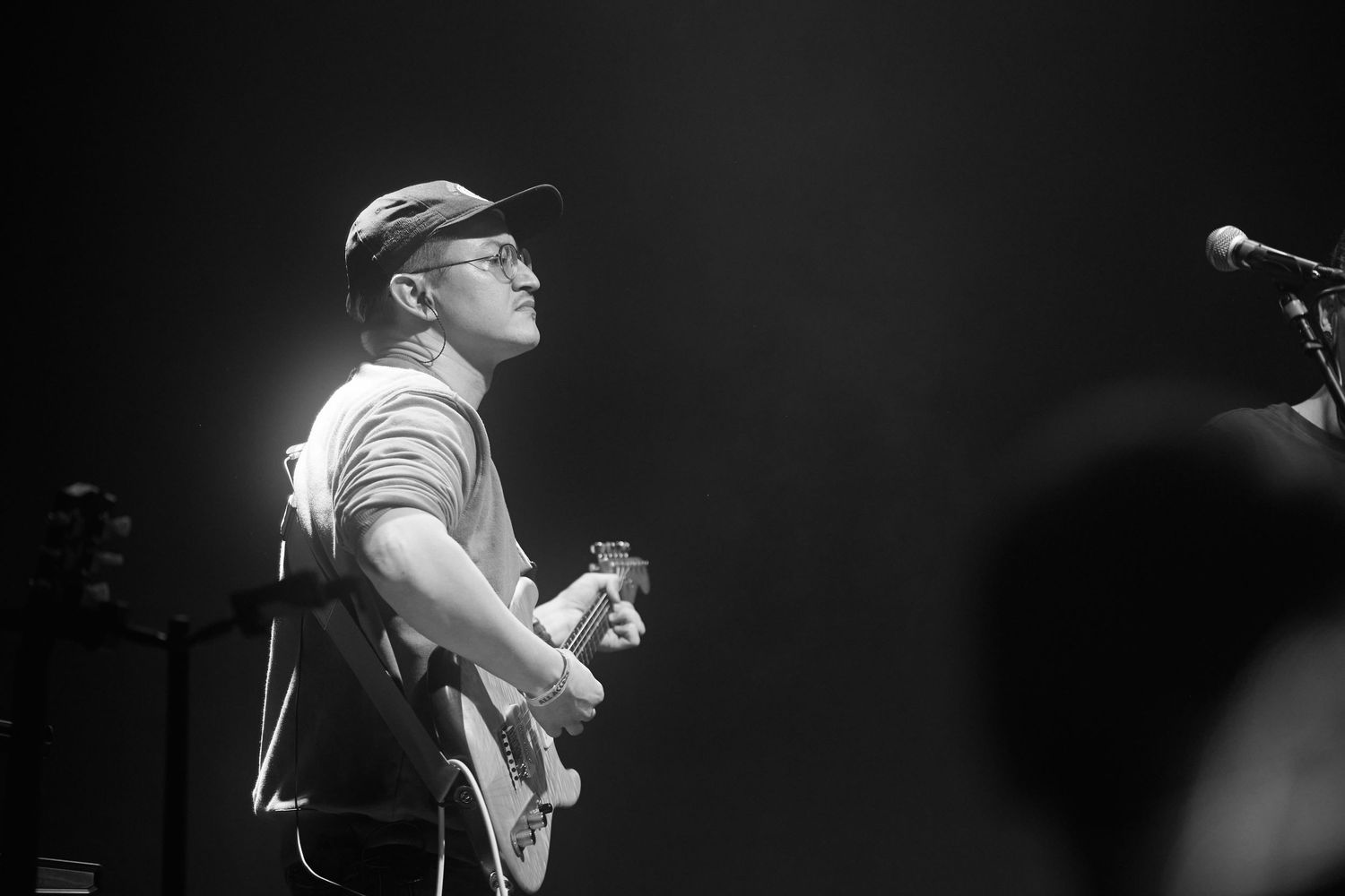 A series of black and white concert performance photos showing musicians on stage in dramatic lighting.