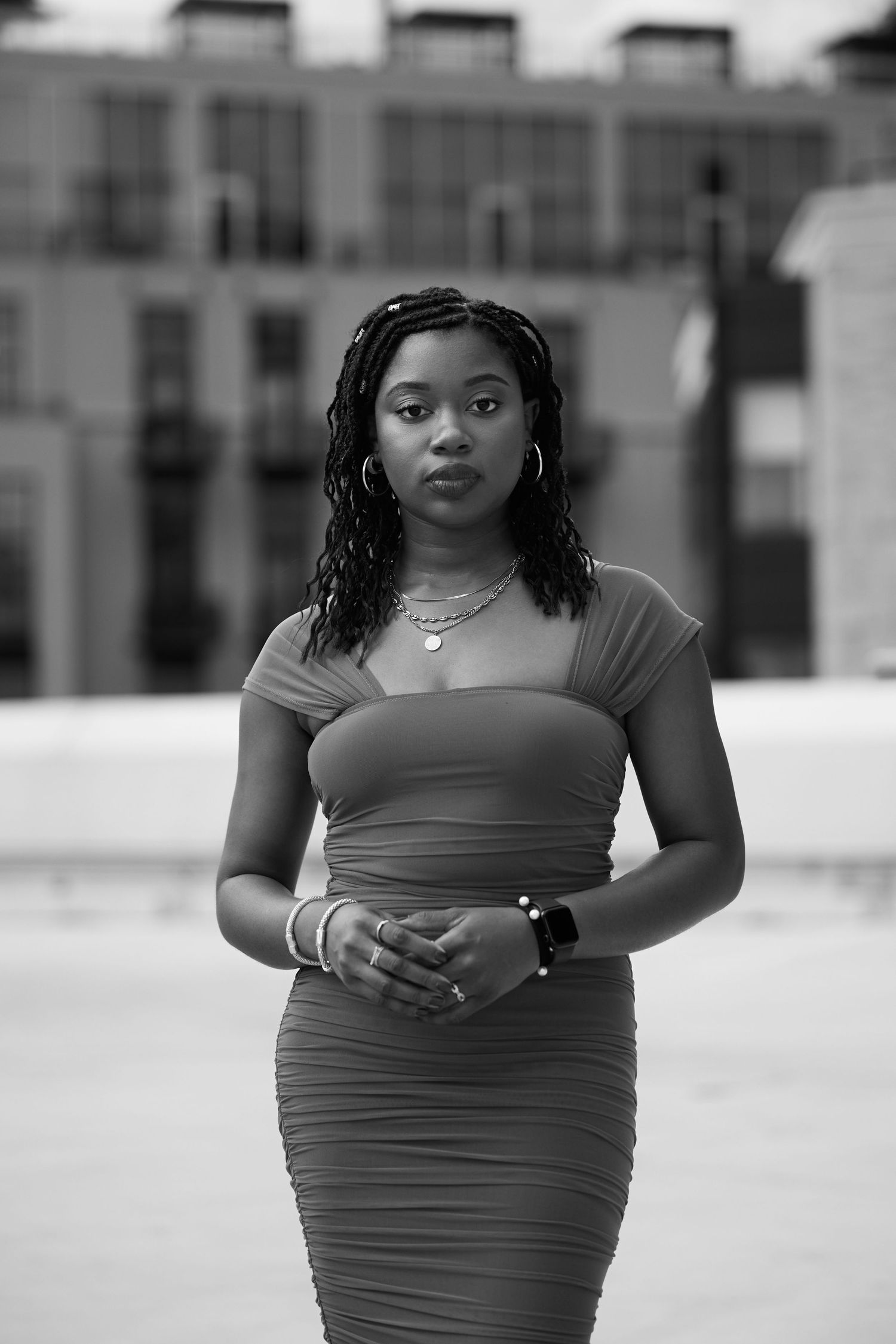 A black and white photo series showing a woman in casual attire posing on a rooftop..