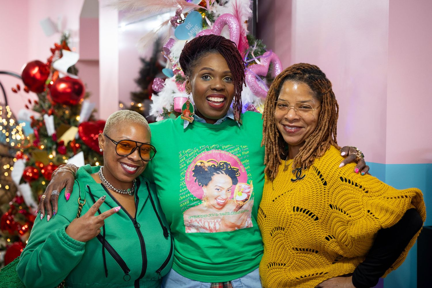 A group of people wearing bright green and yellow clothing celebrate joyfully together during a festive holiday gathering.