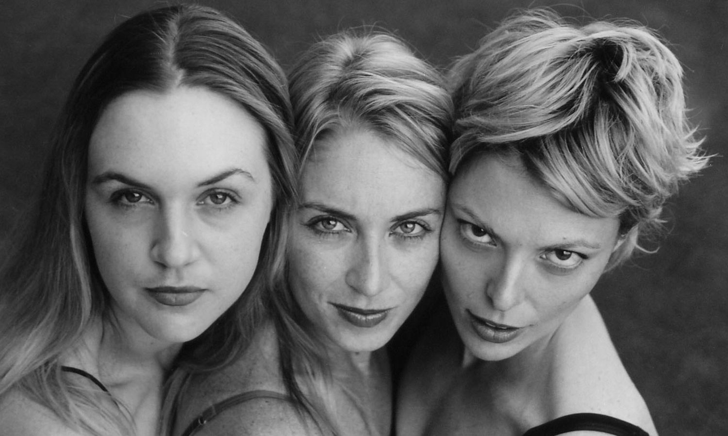 Monochrome theatrical portrait of three expressive women posing together. Photo by Raymond Mather.