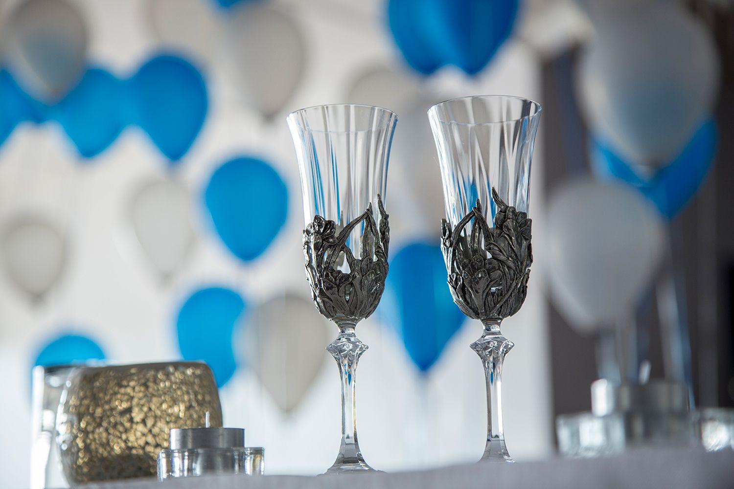 Colour close-up of elegant champagne glasses and blue-white décor before the celebration begins. Photo by Raymond Mather.