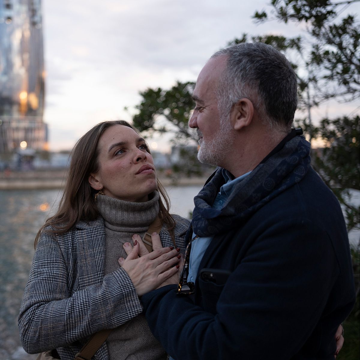 A dramatic sequence shows a struggle between two people at dusk with a blurred background.
