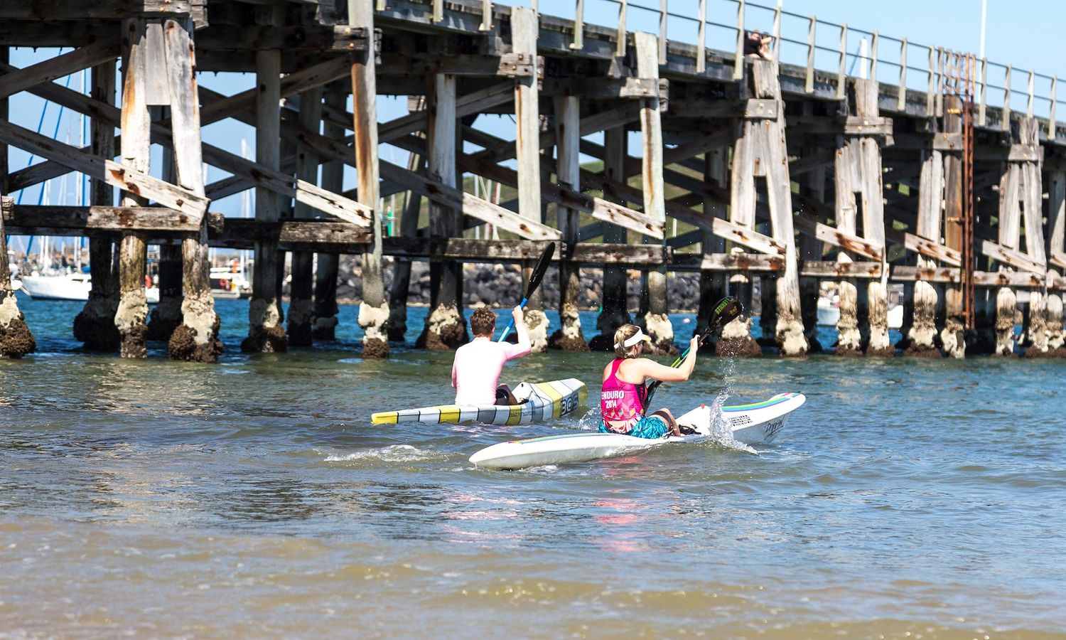 Two kayakers gliding beneath Coffs Harbour Jetty, symbolising teamwork, movement, and joy of outdoor life. Photo by Raymond Mather.