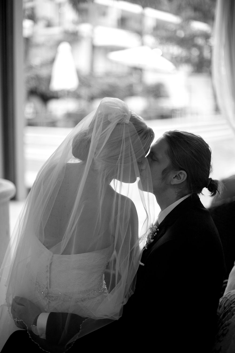 Silhouette profile shots of a couple with flowing veil in dramatic lighting. Photography by Raymond Mather.