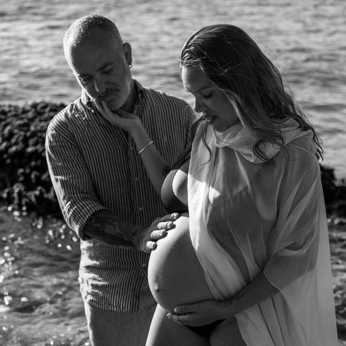 Expectant couple by the sea, calm, trust, and the rhythm of new beginnings. Photo by Raymond Mather.