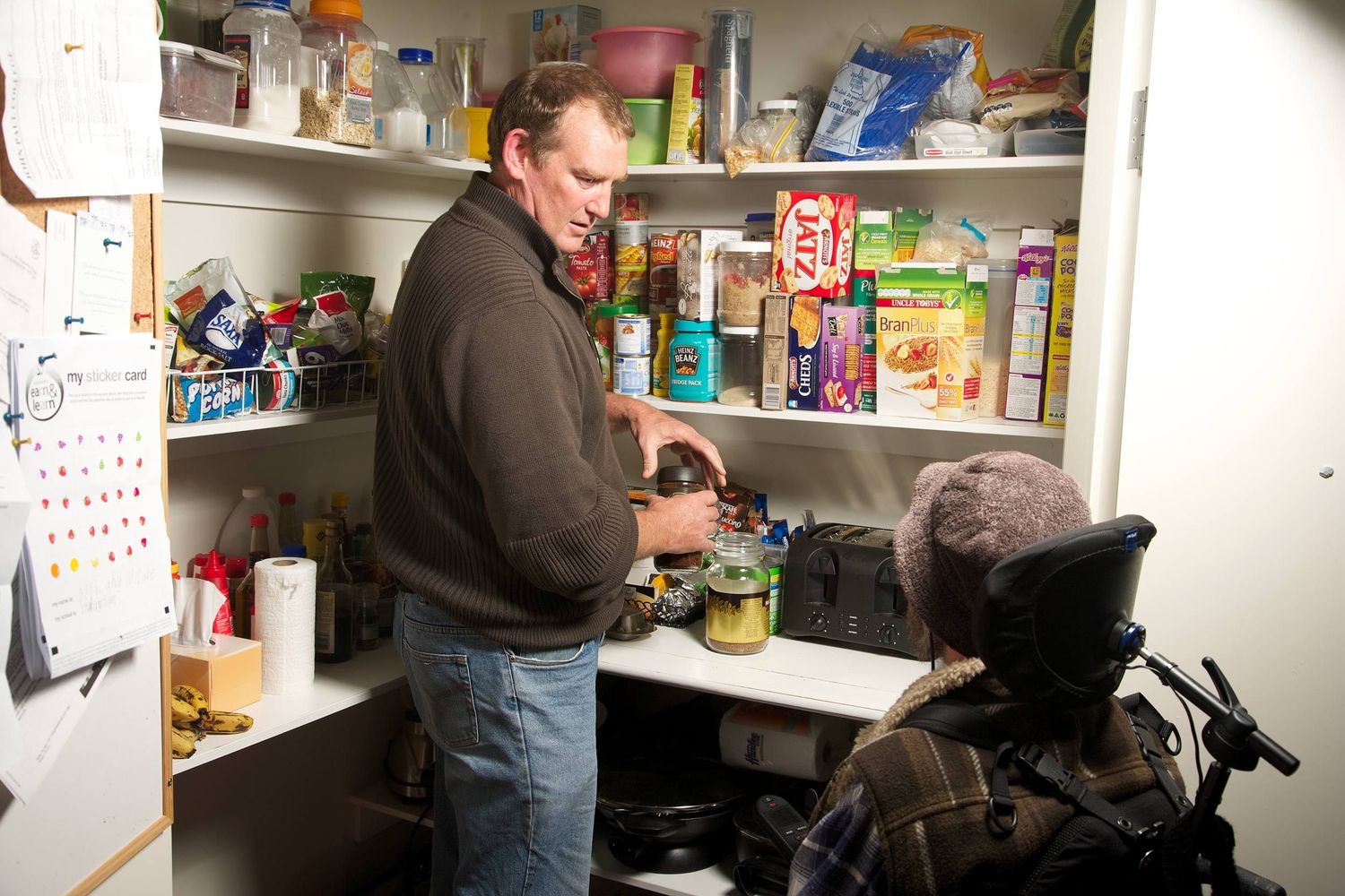 Support worker preparing kitchen space with client in wheelchair, symbolising empowerment, inclusion in daily life. Photo by Raymond Mather.