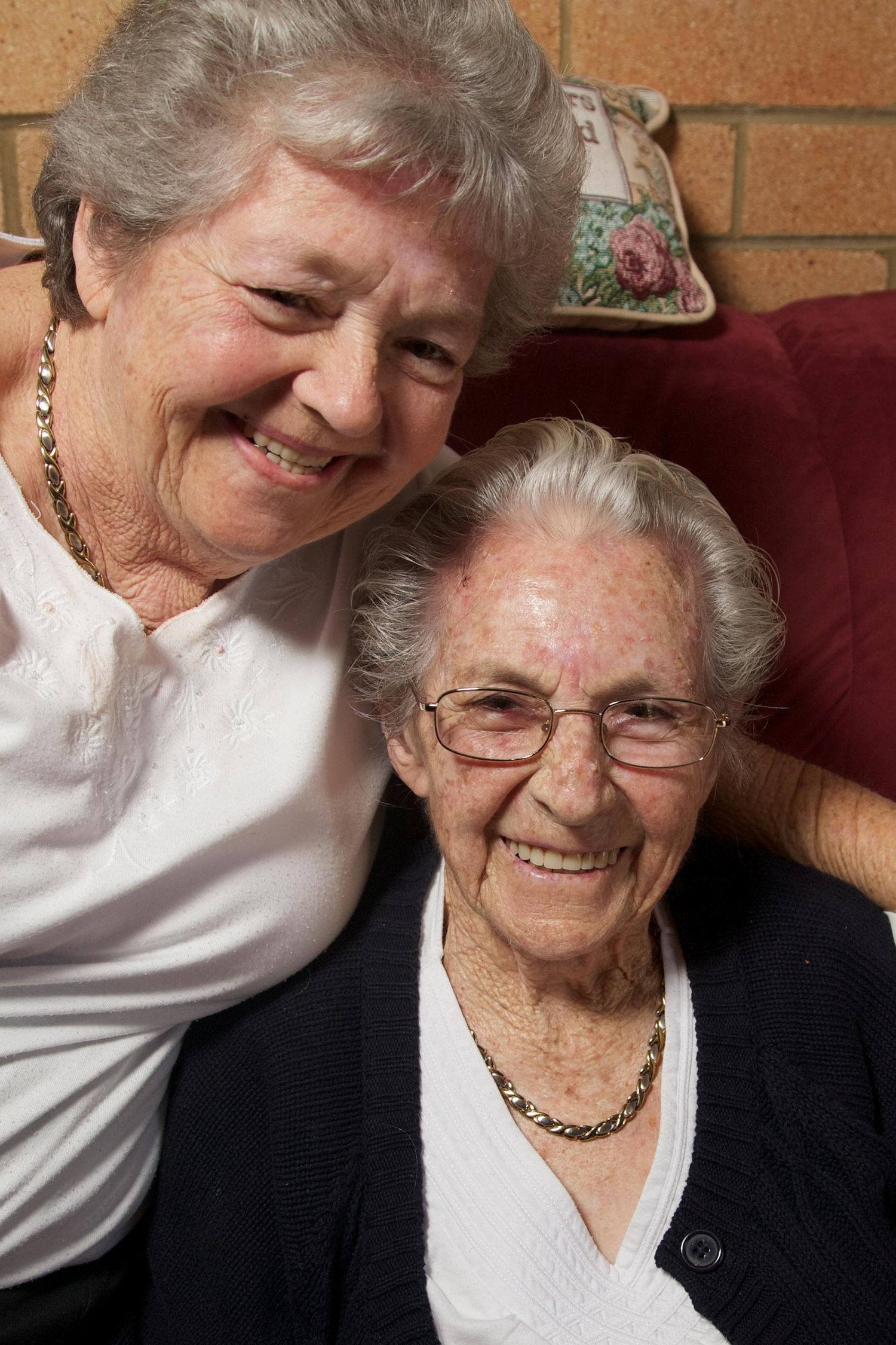 Colour image of two women sharing a warm embrace, their smiles reflecting deep friendship and care. Photo by Raymond Mather.