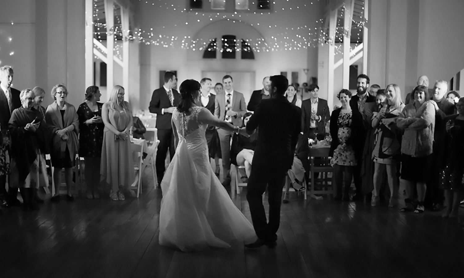 Black and white version of the first dance, capturing quiet emotion and cinematic contrast. Photo by Raymond Mather.