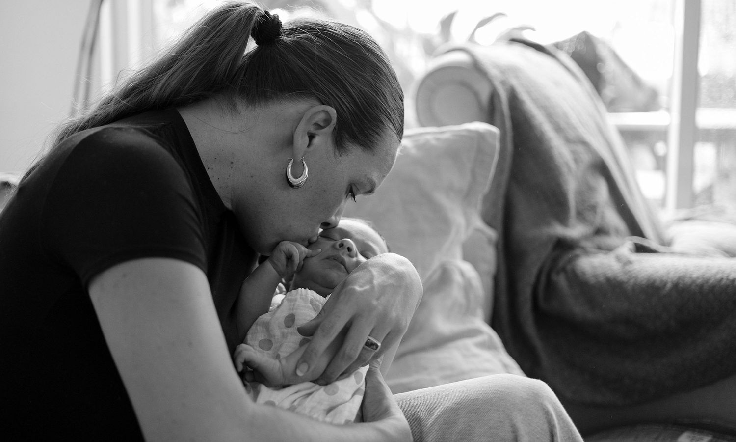 Black and white photo sequence shows a mother and newborn bonding in a hospital setting.