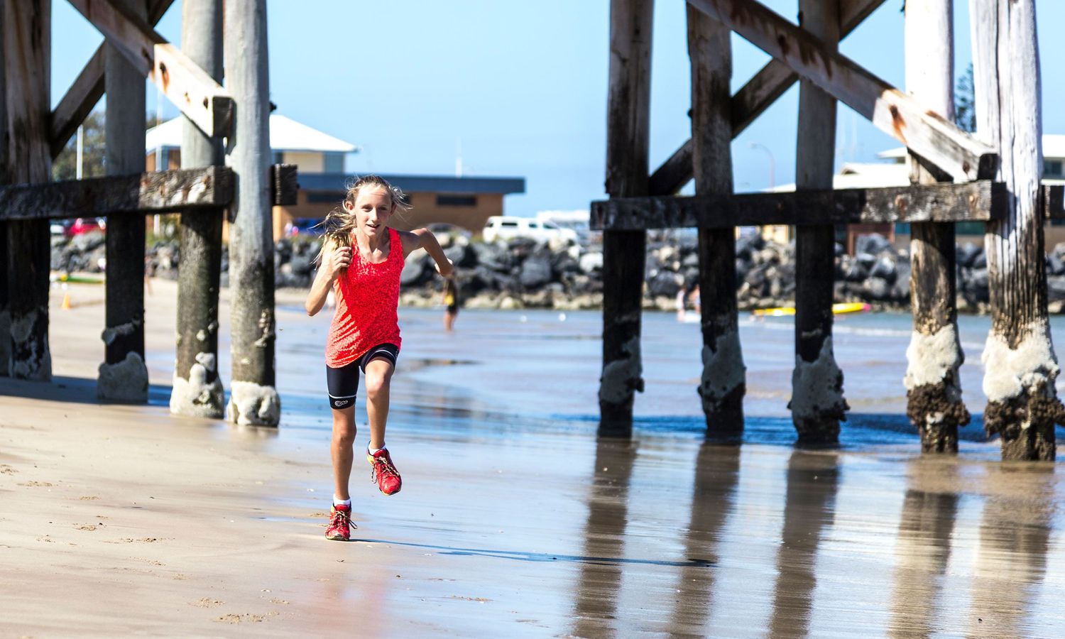Colour photograph, child running Coffs Harbour Jetty, reflecting energy, health, freedom of coastal life. Photo by Raymond Mather.