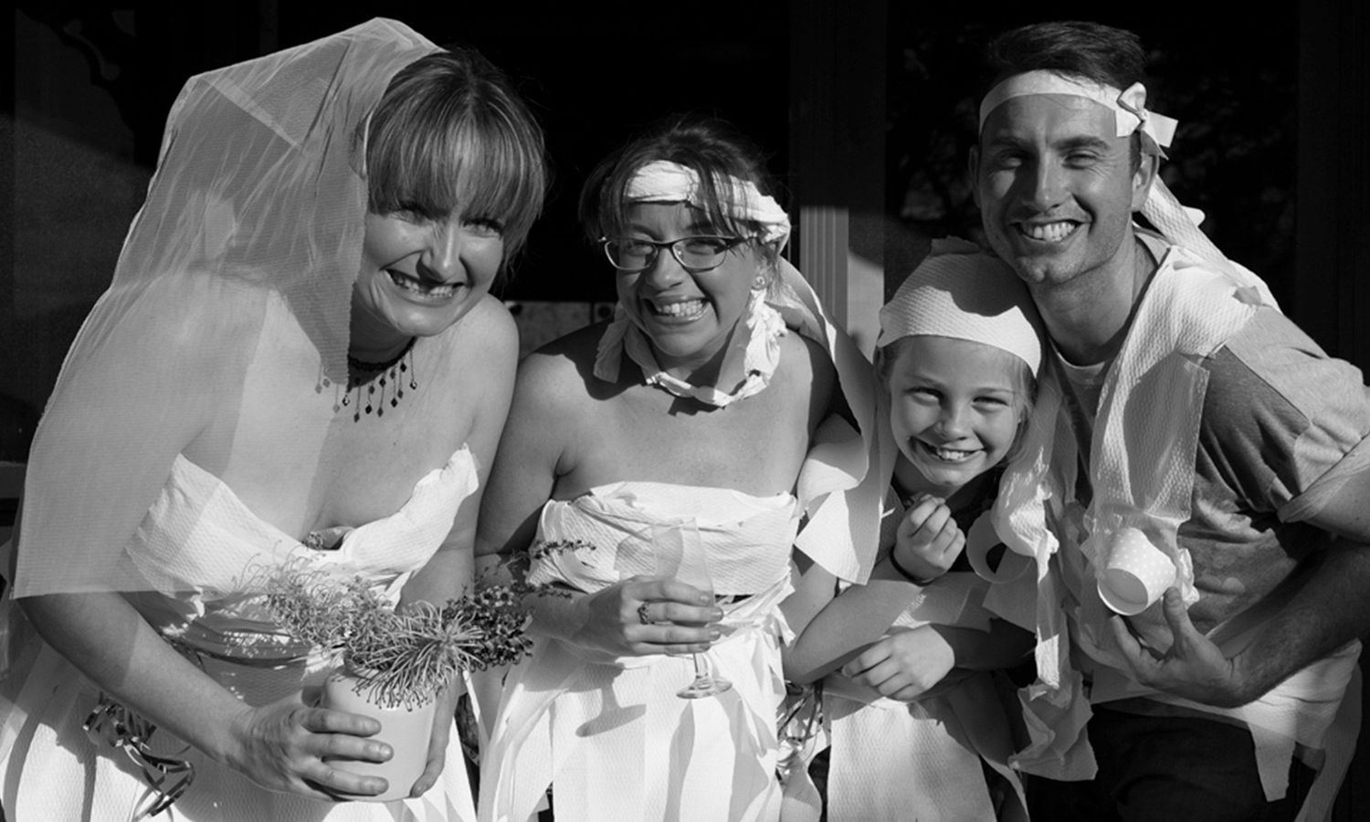 Black and white version of a joyful bridal shower moment, full of playful energy and connection. Photo by Raymond Mather.